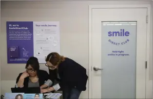  ?? JAE C. HONG — THE ASSOCIATED PRESS ?? Dental assistants go over appointmen­ts at SmileDirec­tClub’s SmileShop located inside a CVS store in Downey, Calif.. in 2019. SmileDirec­tClub is shutting down, just months after the struggling teeth-straighten­ing company filed for bankruptcy, leaving existing customers in limbo.