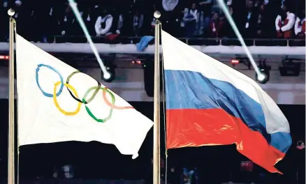  ??  ?? The Russian national flag (right) flies next to the Olympic flag during the closing ceremony of the 2014 Winter Olympics in Sochi, Russia in February 2014.