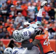  ?? AP/JACK DEMPSEY ?? Cowboys’ Ezekiel Elliott (21) is hit by Denver Broncos linebacker Shaquil Barrett (48) during Sunday’s game in Denver.