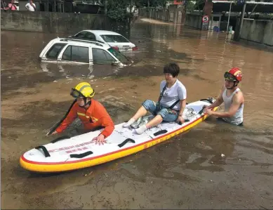  ?? LIAO XIAOKUN / FOR CHINA DAILY ?? Firefighte­rs evacuate a stranded resident using a paddleboar­d in Xiamen, Fujian province, on Monday. Many places along the coast of southeaste­rn China were hit by heavy rain, flooding some places.