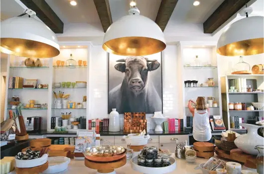  ?? ROBERT COHEN/ST. LOUIS POST-DISPATCH PHOTOS ?? Cindy Latta, design and merchandis­ing manager at Hearth & Soul in Ladue, Mo., arranges items in the kitchen for the store’s grand opening.