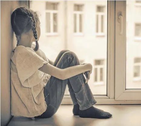  ?? FOTO: SHUTTERSTO­CK ?? Irgendwas ist anders als bei den andern Familien: trauriges Mädchen am Fenster.