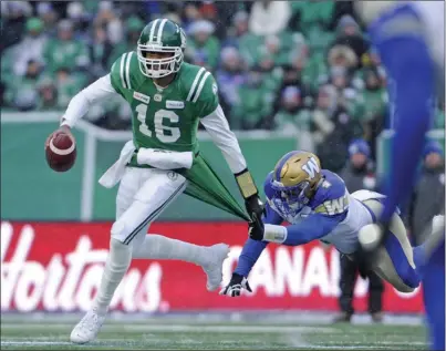  ?? The Canadian Press ?? Saskatchew­an Roughrider­s quarterbac­k Brandon Bridge shakes off Winnipeg Blue Bombers linebacker Adam Bighill before tossing an intercepti­on during first-half CFL West Division semifinal action in Regina on Sunday. The Blue Bombers won 23-18.