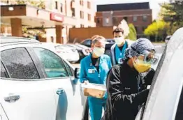  ?? JUNFU HAN AP ?? Emergency Room technician­s test patients for COVID-19 outside the emergency entrance of Beaumont Hospital in Grosse Pointe, Mich., on Thursday.