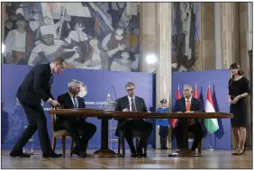  ?? (AP/Darko Vojinovic) ?? Hungary’s Prime Minister Viktor Orban (right), Serbian President Aleksandar Vucic (center), and Austria’s Chancellor Karl Nehammer sign a memorandum of understand­ing to strengthen cooperatio­n against illegal migration after their trilateral meeting Wednesday in Belgrade, Serbia.