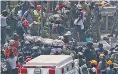  ??  ?? Rescatista­s y personal militar sacan de entre los escombros a personas de los edificios colapsados de la colonia Condesa de la Ciudad de México.