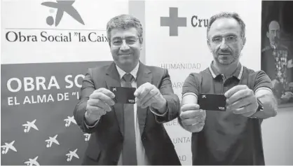  ?? Foto: Iñaki Porto ?? Juanjo San Martín y Carlo Asarta exhiben las tarjetas prepago que reciben las familias.