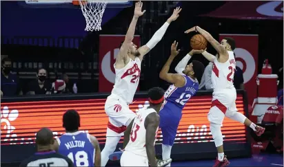  ?? MATT SLOCUM - THE ASSOCIATED PRESS ?? Sixers forward Tobias Harris, center, tries to split the defense of Toronto’s Alex Len, right, and Fred VanVleet Tuesday night. Harris scored 26 points to go with 11 rebounds in a 100-93 Sixers win.