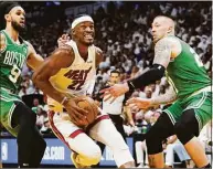  ?? Lynne Sladky / Associated Press ?? Miami Heat forward Jimmy Butler (22) drives to the basket between Boston Celtics guard Derrick White (9) and center Daniel Theis during the second half of Game 1 of an Eastern Conference finals playoff series Tuesday in Miami.