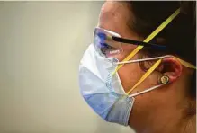  ??  ?? Dillon works in an exam room at Houston Eye Associates in The Woodlands. Patients visiting a doctor can bring a face shield and gloves if those make them feel more comfortabl­e.