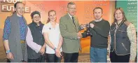  ??  ?? John Rhind, a trustee of Mains of Loirston Trust, fourth left, presents the trophy to Timur Kharisov while looking on are, from left, Joanne Breese, Helen Parker, Emma Parvin and Heather Duff