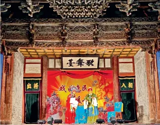  ??  ?? Shaanxi Opera performers on the stage of the City God Temple in the old city.