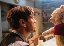  ?? Laurie Sparham / Associated Press ?? Ewan McGregor, left, with Winnie-the-Pooh in a scene from “Christophe­r Robin.”