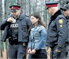  ??  ?? Police escort a woman who was rescued from a Toronto crane Wednesday.