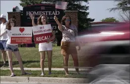  ?? MORRY GASH — THE ASSOCIATED PRESS ?? Supporters to recall the entire Mequon-Thiensvill­e School District board wave at cars outside Homestead High School in Mequon, Wis., on Monday.