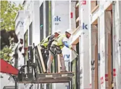  ??  ?? CHICAGO: This file photo taken on May 14, 2017 shows workers installing windows in a townhome complex under constructi­on in Chicago, Illinois. — AFP