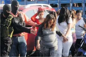  ?? MARVIN RECINOS/AFP/GETTY IMAGES ?? Alleged members of the MS-13 gang are presented to the press in San Salvador in 2016 after a police operation aimed at dismantlin­g the gang’s money laundering schemes. The money was allegedly funnelled through businesses such as motels, public...