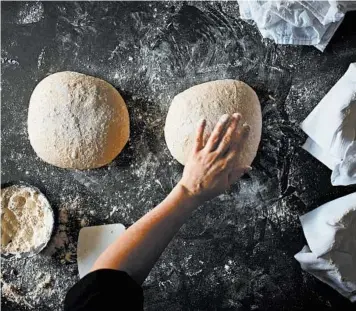  ?? JOHNNY MILLER/THE NEW YORK TIMES, LAURIE PELLICANO/FOOD STYLING ?? Dough is shaped for sourdough bread. As families continue to stay at home, one thing’s for sure: Americans are baking.