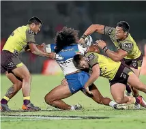  ?? PHOTO: GETTY IMAGES ?? Tohu Harris of the Warriors is triple-teamed by Brisbane Broncos defenders during the NRL match in Auckland on Saturday night.