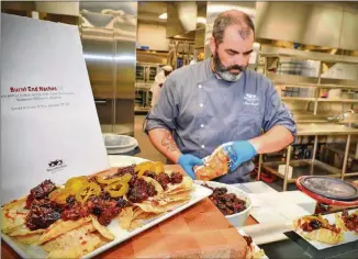  ?? PHOTOS CONTRIBUTE­D BY CHRIS HUNT/SPECIAL ?? Chef Alan Knight prepares Burnt End Nachos for tasting. The nachos are made of burnt ends of brisket, tortilla chips, white cheese sauce, Budweiser BBQ sauce and jalapenos and served at Smoke N Pour, sections 117 and 316.