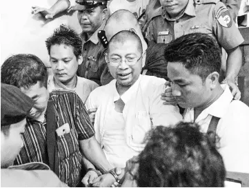  ??  ?? Pamaukkha (centre) leaves following a court appearance in Yangon. — AFP photo