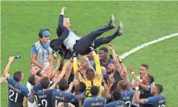  ??  ?? French players throw France head coach Didier Deschamps into the air after beating Croatia in the World Cup championsh­ip match Sunday in Moscow. France won 4-2.