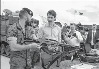  ?? CP PHOTO ?? Canadian Prime Minister Justin Trudeau, centre, inspects the troops as he visits Adazi Military Base in Kadaga, Latvia, on Tuesday.