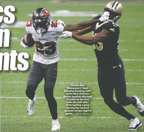  ?? GETTY IMAGES ?? Tampa Bay Buccaneers' Sean Murphy-Bunting stiffarms New Orleans Saints receiver Michael Thomas as he runs with the ball after intercepti­ng a pass during the second quarter of last night's game.