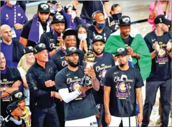  ?? GETTY IMAGES/AFP ?? The Los Angeles lakers, fueled by LeBron James (centre), captured the team’s 17th NBA championsh­ip trophy, the first in more than a decade. James was named MVP.