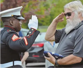  ?? STAFF PHOTOS BY CHRIS CHRISTO ?? HONOR: The families of Pfc. David McAfee and Neil Ellsworth gather last week in Northboro for a rededicati­on of the Ellsworth McAfee Park. Above, McAfee’s brother, Paul, right, receives a flag from Marine Sgt. Kenji Kamara, who folded the flag with...