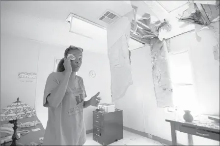  ?? PHOTOS BY BRANDON DILL/SPECIAL TO THE COMMERCIAL APPEAL ?? Vance Avenue Youth Developmen­t Center director Barbara Nesbit wipes sweat from her brow while explaining the extent of damage from last Friday’s storm when a tree hit the roof, allowing rain to pour inside. Nesbit said about 100 youths regularly visit...