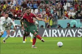  ?? PETR DAVID JOSEK — THE ASSOCIATED PRESS ?? Portugal’s Bruno Fernandes scores his side’s second goal from the penalty spot during a World Cup Group H match against Uruguay at the Lusail Stadium in Lusail, Qatar, on Monday.