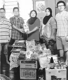  ??  ?? Lim (second left) hands over the items to Kasminah.