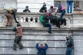  ?? Associated Press file photo ?? Rioters supporting President Donald Trump climb the west wall of the the U.S. Capitol on Jan. 6.