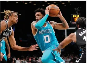 ?? (AP/John Minchillo) ?? Charlotte Hornets forward Miles Bridges (center) drives past Brooklyn Nets guard James Harden (right) and forward Nic Claxton during the first half Sunday in New York. Bridges led the Hornets with 32 points in a 111-95 victory.