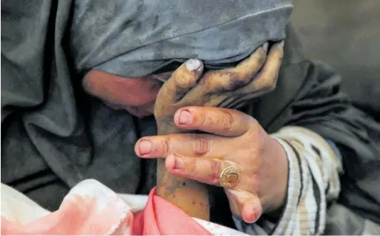  ?? HATEM KHALED (REUTERS) ?? El desconsuel­o de una madre. La palestina Buthayna Abu Jazar mantenía ayer en sus brazos a su hijo Hazma, al que mató una de las bombas israelíes lanzadas sobre la zona de Rafah, en el sur de la franja de Gaza. En los siete meses que dura ya esta guerra, han muerto 34.900 palestinos; de entre ellos se calcula que más de 14.000 eran menores.