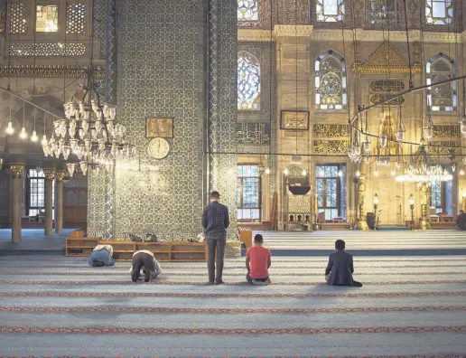  ??  ?? Muslim people pray at the Yeni Cami mosque, which was completed in 1665 upon the orders of Sultan Mehmed IV’s mother Hatice Turhan Sultan, in Istanbul.