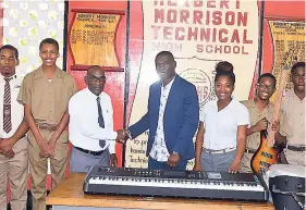  ?? CHRISTOPHE­R THOMAS ?? Paul Adams (third left), principal of Herbert Morrison Technical High School, received musical equipment from Clive Heath, a member of the Herbert Morrison Technical High School New York Tri-State Chapter and past student of the institutio­n, during a handover ceremony at the school on Monday, November 19. Also pictured are Kenisha Samuels, music and mathematic­s teacher at the school, and several students of the institutio­n.