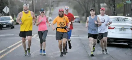  ?? The Sentinel-Record/Mara Kuhn ?? CROSS-COUNTRY RUN: Rob Pope, front, center, runs with members of the Spa Pacers on Quapaw Avenue to his place to stay for the night after he was presented with a Spa Running Festival T-shirt and medal and Descendant of DeSoto certificat­e at The Greater...