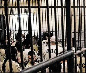  ?? E. JASON WAMBSGANS/CHICAGO TRIBUNE ?? Detainees wait for court appearance­s in a holding cell at Cook County Jail in 2019. In 2017, the county began using money bonds less often.