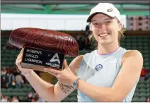  ?? — AFP photo ?? Swiatek poses with the winners trophy.