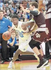  ?? Jae C. Hong Associated Press ?? ISAAC HAMILTON of UCLA is pressured by Texas A&M’s D.J. Hogg in Wooden Legacy title game.