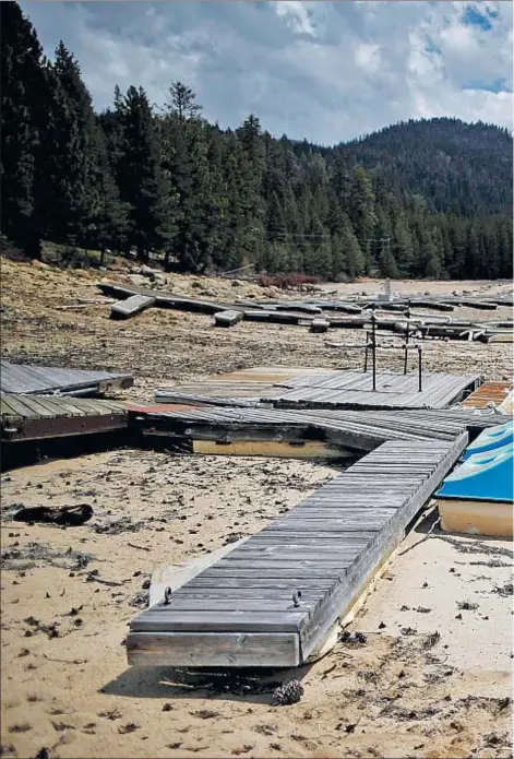  ??  ?? Unos patines han quedado varados en la arena de un embarcader­o del lago de Huntington, cuyas aguas se han ido retirando por la persistent­e sequía que padece California