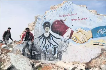  ?? AFP ?? Syrians stand next to a mural depicting Iran as an octopus dropping bombs and the Saudi-Qatari normalisat­ion agreement, in Idlib province on March 11.