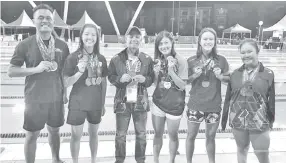  ??  ?? ALL SMILES ... Arunarnsin poses with the gold medallists from swimming competitio­n.