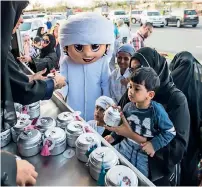  ??  ?? Omeir, the mascot, guides kids as they get their share of gifts from the Hamdan Bin Mohammed Heritage Centre on Saturday in Dubai.