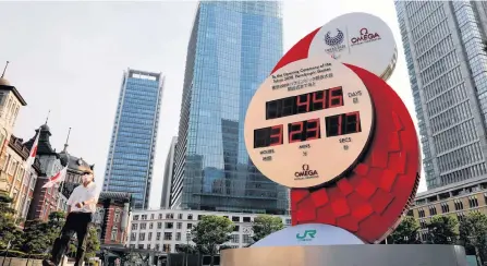  ?? REUTERS ?? A man wearing a protective mask walks past a countdown clock for the Tokyo 2020 Olympic Games on June 4 amid the coronaviru­s disease (COVID-19) outbreak in Tokyo.