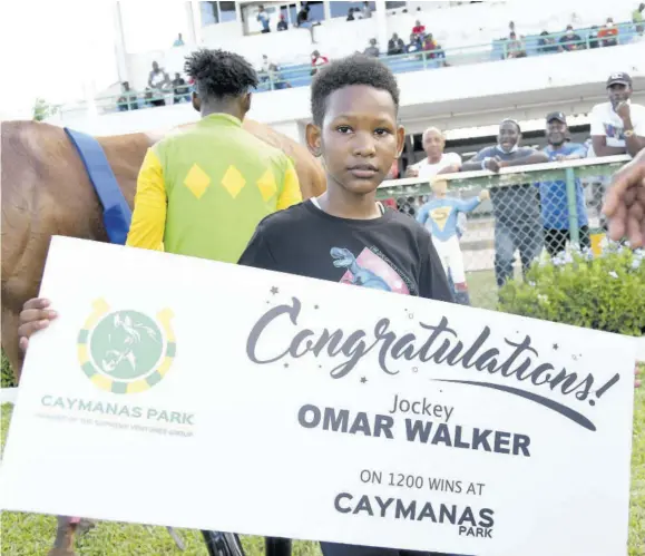  ?? ?? Omar Walker Jr proudly displays that his father is now a winner of 1,200 races at Caymanas Park.