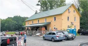  ??  ?? People stand outside The Painted Mill in Fallston during one of the business’ tag sales.