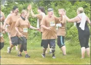  ?? Peter Hvizdak / Hearst Connecticu­t Media ?? Chris Scranton, 53, of West Haven high-fives a teammate as he runs toward the finish line on Saturday.